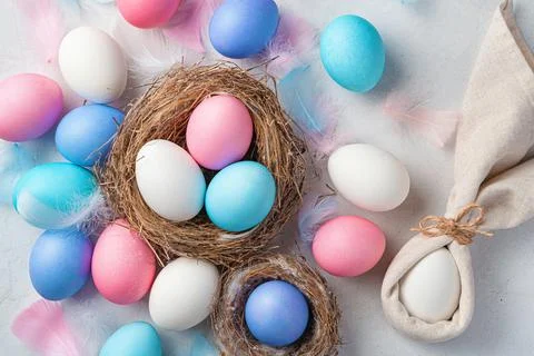 Festive background with Easter eggs and a rabbit on a gray background. Top vi Stock Photos