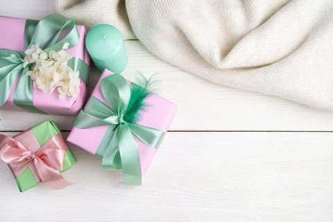 Festive background with gift boxes, candles and a sweater on a white wooden Stock Photos