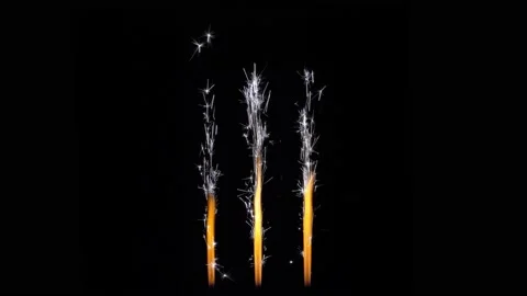 Festive background layout. Three cold sparkling Bengal fountains on black. Th Video stock 148723905