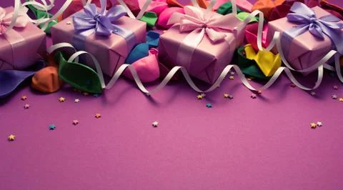 Festive background of purple material colorful balloons streamers confetti fo Stock Photos
