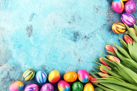 Festive background setting for Easter with eggs and tulips Stock Photos