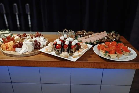 Festive banquet table loaded with various appetizers, cheese platter with Stock Photos
