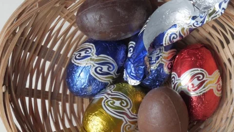 Festive Basket of Colorful Chocolate Easter Eggs Wrapped in Shiny Foil Stock Footage 331903881