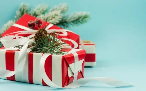Festive boxes in red packaging with branches and cones, berries and ribbons.. Stock Photos