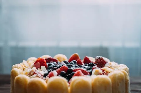 Festive cake decorated with bright forest berries. Stock Photos