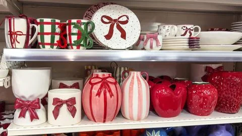 Festive ceramic tableware with bows and gift-themed designs displayed on stor Stock Photos