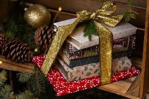 Festive Christmas Book Stack Gift with Golden Glitter Ribbon and Pine Branche Stock Photos