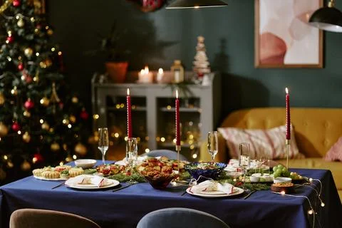 Festive Christmas Dinner Table Setting with Food and Lit Candles Stock Photos