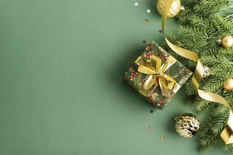 Festive Christmas present wrapped in patterned paper with gold ribbon and o.. Stock Photos
