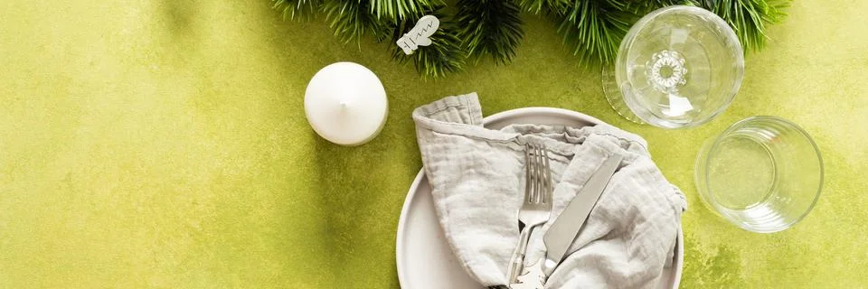 A festive Christmas table setting with an empty plate, cutlery, and napkin on Stock Photos