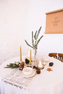 Festive Christmas table setting with eucalyptus, candles, and pinecones for Stock Photos
