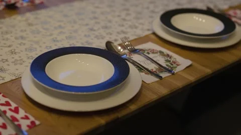 A festive Christmas table setting features white plates with textured blue rims Stock Footage 324920847