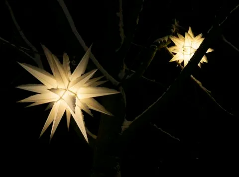 Festive Christmas tree lantern in the shape of a star glowing in the night Stock Photos