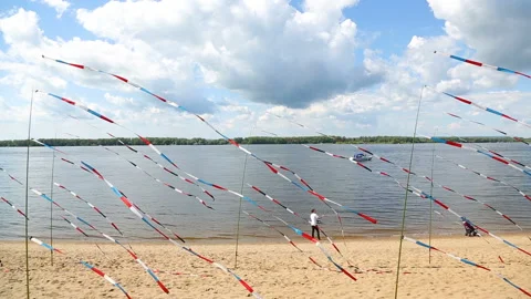 Festive colorful flags on the sand beach on a sunny day Stock Footage 125878544