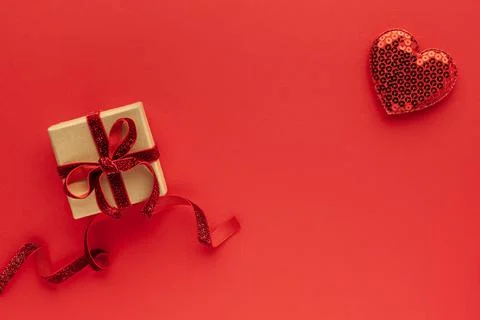 Festive composition with gift box and hearts on red background. Top view, cop Stock Photos