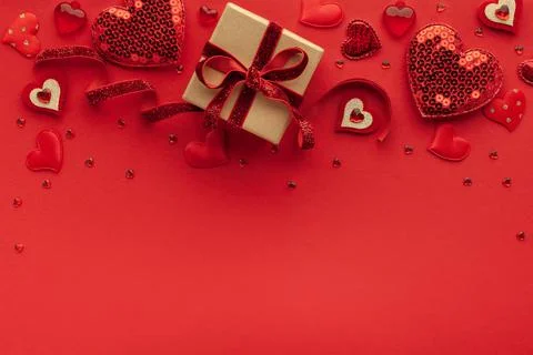 Festive composition with gift box and hearts on red background. Top view, cop Stock Photos