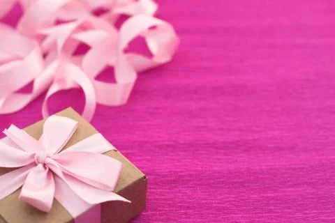 Festive composition with gift box on a bright pink background. Stock Photos