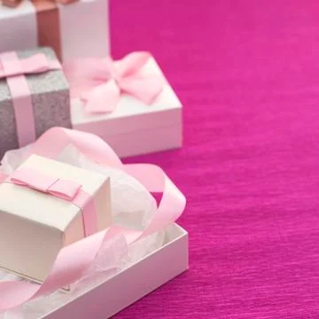 Festive composition with gift box on a bright pink background. Stock Photos