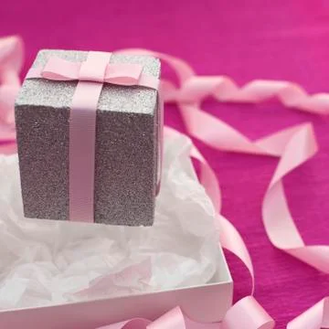 Festive composition with gift box on a bright pink background. Stock Photos