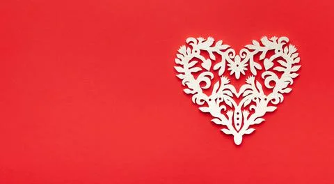 Festive composition with openwork white heart on red background. Top view, co Stock Photos