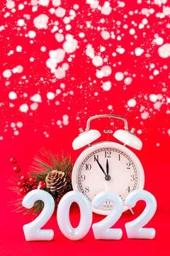 Festive composition with pine branch, alarm clock and candle number 2022, red 스톡 사진