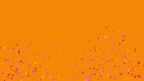 Festive Confetti Explosion on Bright Orange Background Stock Footage 336662586