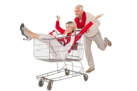 Festive couple messing about in shopping trolley Stock Photos