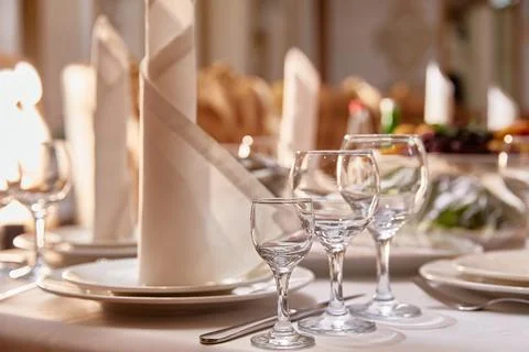 Festive covered table with cutlery, beautiful glasses and a napkin in restaurant Stock Photos