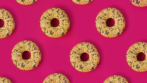 Festive creative pattern of rows of donuts on pink background Stock Photos