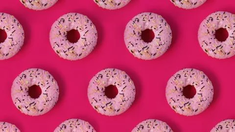 Festive creative pattern of rows of donuts on pink background Stock Photos
