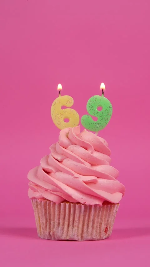 Festive cupcake with candles number 69 on a pink background. Holiday concept Stock Footage 274497316