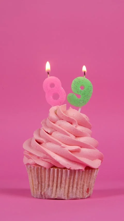 Festive cupcake with candles number 89 on a pink background. Holiday concept Stock Footage 274843720