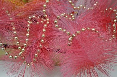 Festive decor background composition of pink tinsel with gold beads for the.. Stock Photos