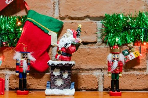 Festive decorations with Santa, nutcrackers, and stockings against a brick wa Stock-Fotos