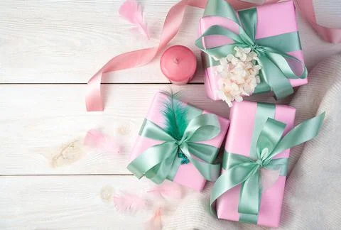 A festive delicate composition with gift boxes, a ribbon, candles and a white Stock Photos