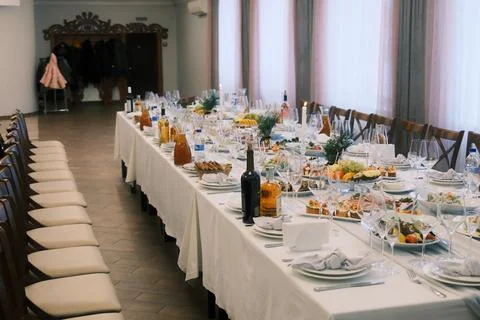 Festive dining table arranged in a spacious event hall Stock Photos