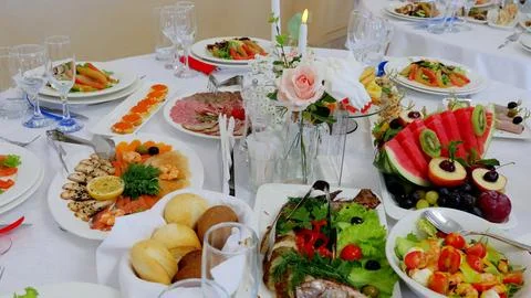 Festive dining table displaying colorful appetizers, salads, fruits, and Photos