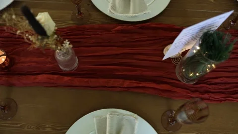 Festive dining table with red runner and white plates Stock Footage 337723021