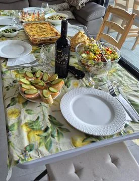 A festive dining table set with assorted salads, appetizers, wine, and baked Stock Photos