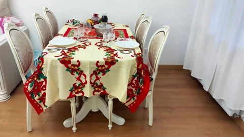 Festive Dining Table Set with Plates, Glasses, and Floral Tablecloth Stock Footage 325423151