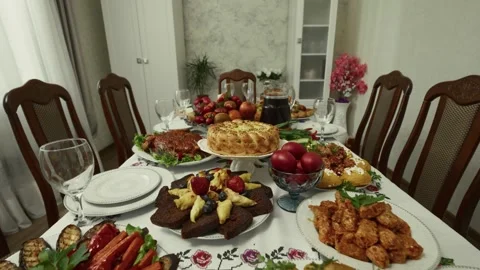 Festive dining table set with various traditional dishes, fruits, and drinks, Stock Footage 332736948