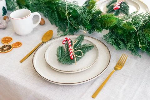 Festive dining table setting with greenery and seasonal Christmas decoratio.. Stock Photos