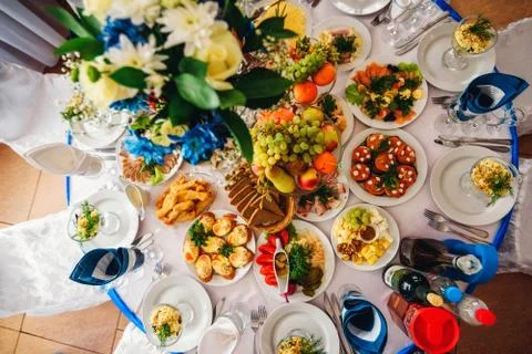 Festive dinner table in the restaurant with various food and drinks Stock Photos
