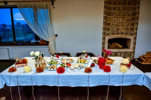 Festive dinner table set in a rustic room with fireplace Stock Photos