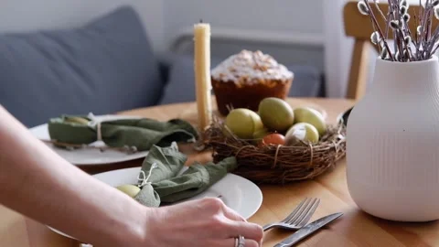 Festive dinner table setting for Easter. A woman puts cutlery on the festive Stock Footage 265947964