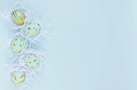 Festive easter background - blue easter eggs with golden glitter design in wh 库存照片