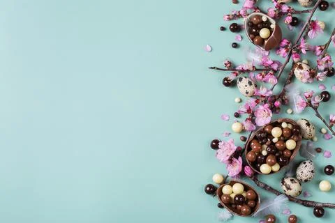 Festive Easter background, chocolate sweets, quail eggs and blooming almond Stock Photos
