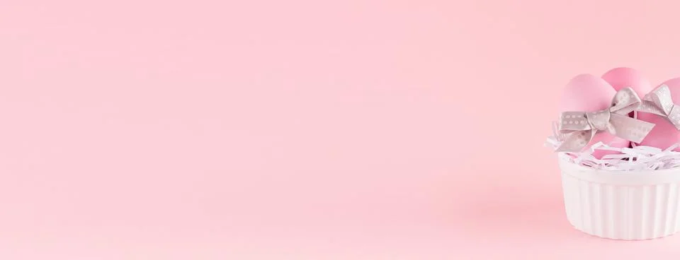 Festive easter banner - pink easter eggs with silver bows in white ceramic bo Stock Photos