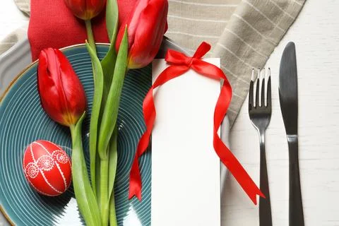 Festive Easter table setting with blank card and flowers on wooden background Stock Photos