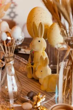 Festive Easter table setting with cute bunny decorations, pastel eggs, and warm Stock Photos